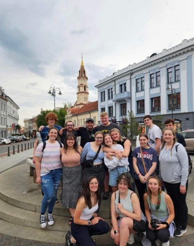 A group of students smiles overseas.