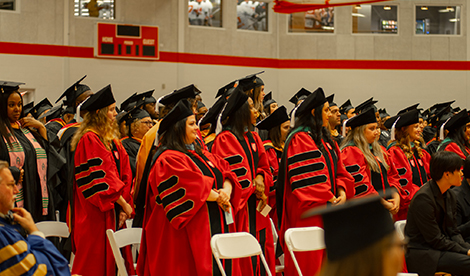 Graduates stand during commencement ceremony