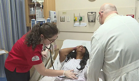 A student and professor work on a patient in the ER simulation lab