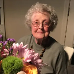 Miriam A. (Whitford) Bailey smiles while holding flowers