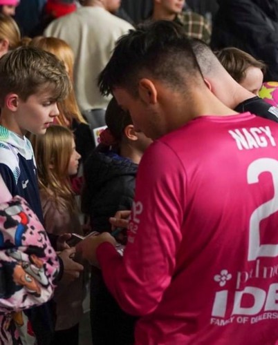 Tamas signs autograph for young child