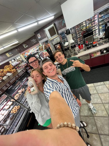 A slefie of a young woman and 3 young men in a store.