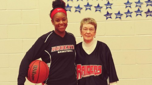 Sue smiles with a women's basketball player.