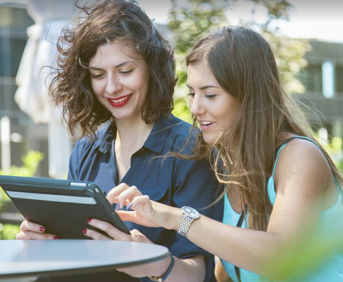 2 women look at a screen together